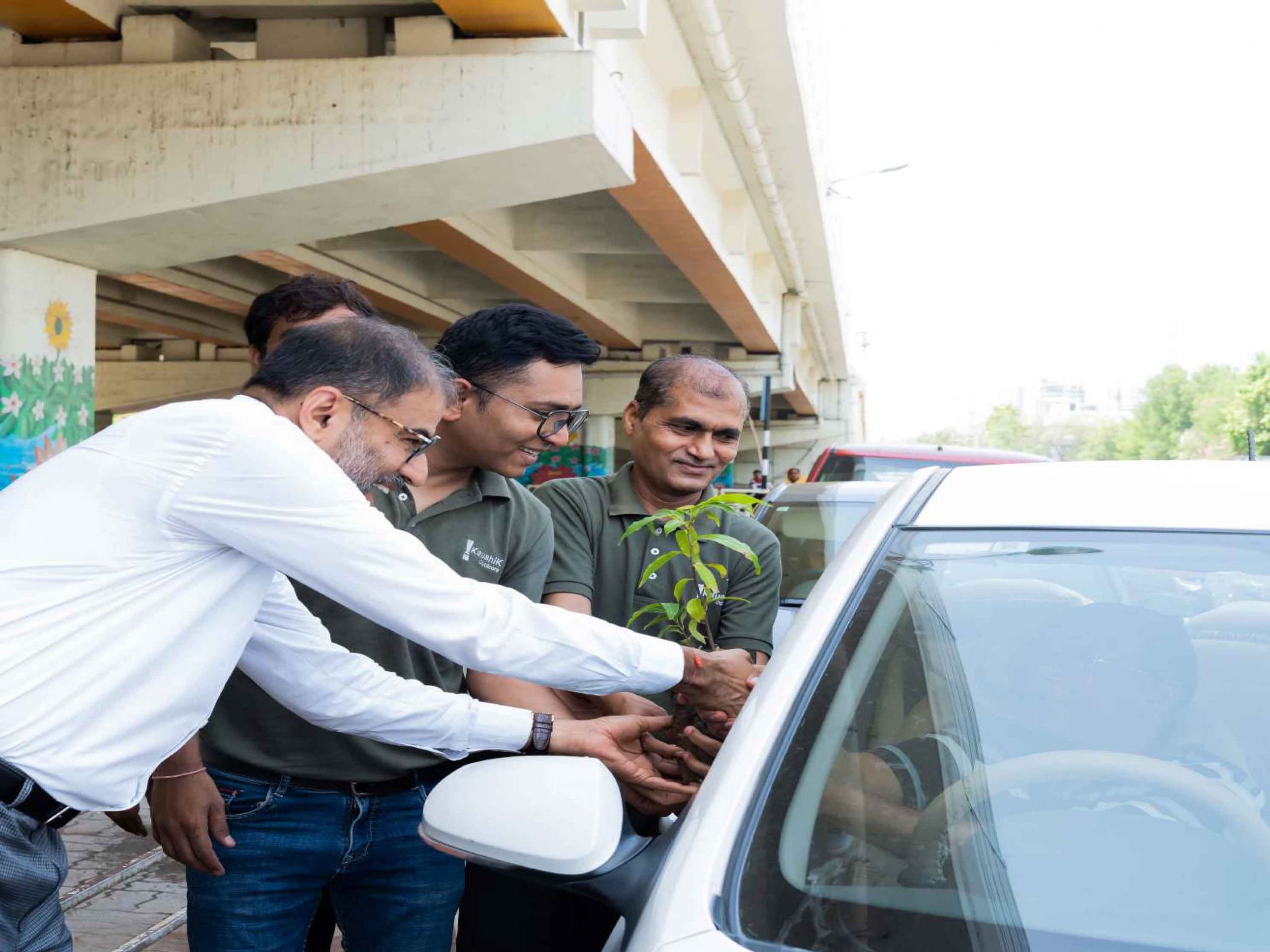 Kaushik outdoors Employees handing out plants as part of green initiative 