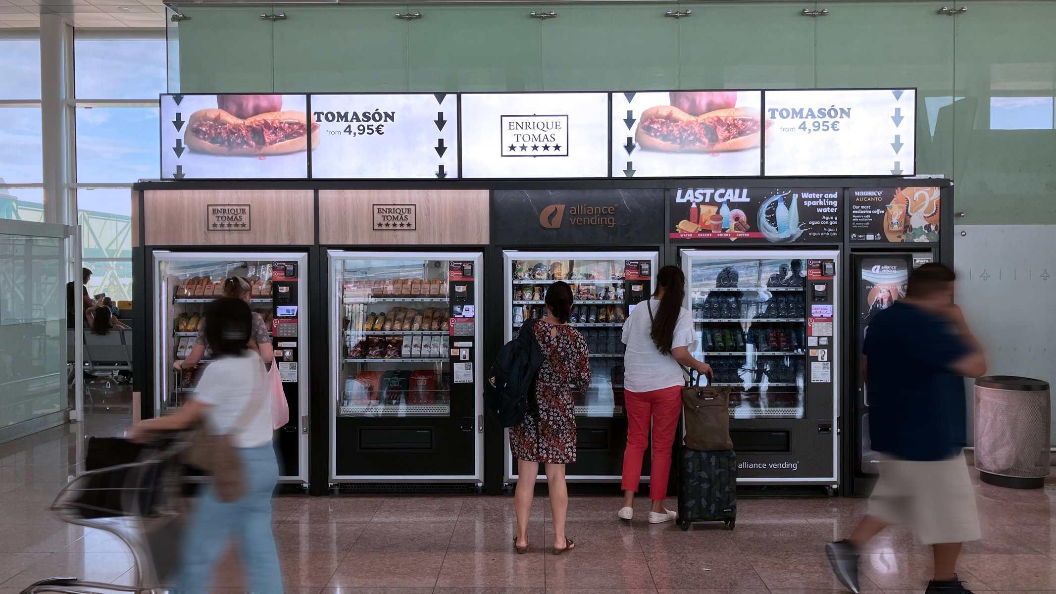 Customers in front of machine, checking the products