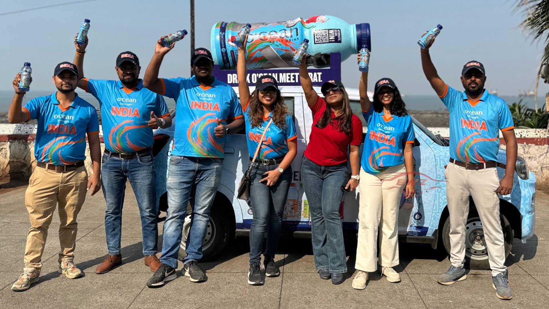People in front of transit campaign holding drinks 